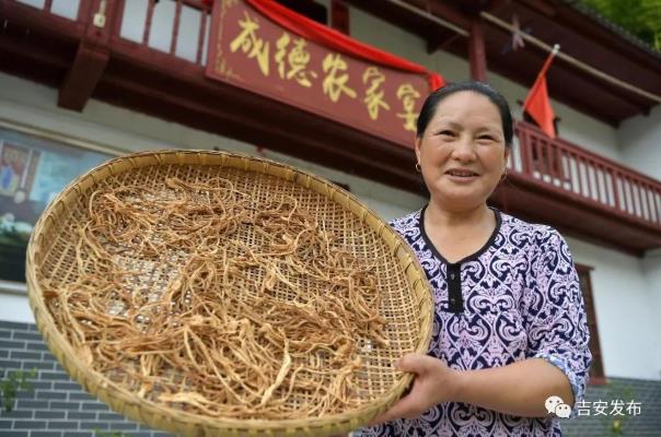 神山村村民彭夏英在自己開的農(nóng)家樂前展示自家的農(nóng)產(chǎn)品